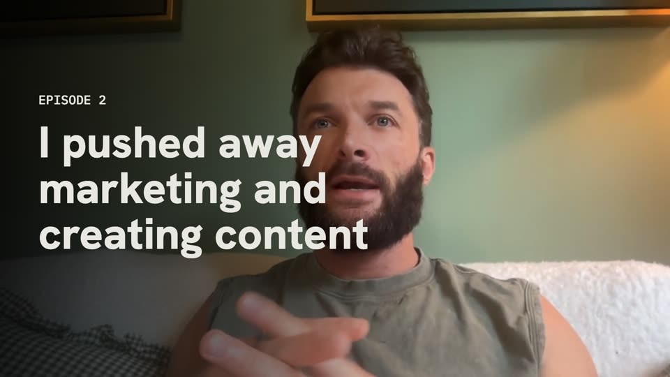 landscape youtube thumbnail for a build in public episode: episode 2, a founder on a sofa with his line about pushing away marketing across the frame